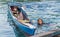 INDONESIA, TOGEAN ISLANDS -MALENGE - JULI 11, 2018: A girl swimming beside traditional wooden boat by bajo village