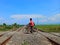 Indonesia, west java, cirebon, june 2021, a young man who is crossing the train track on his bicycle