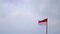 Indonesian flag fluttering in the wind against a cloudy sky background