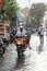 Indonesian man riding a motorbike under the rain, Ubud, Bali