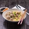 Indonesian Meatball Bakso Noodle with sweet soy sauce and chilli sauce sprinkle with green onion