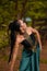 An Indonesian woman poses with black hair dangling to the ground while wearing a green dance costume