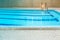 Indoor blue swimming pool with grating between grey tile and mos