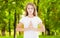 Indoor closeup of beautiful European woman in white T-shirt isolated on park background practicing yoga and meditation