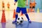 Indoor football futsal training for children. Soccer training dribbling cone drill. Indoor soccer young player with a soccer ball