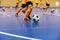 Indoor football training for youth team. Young boys with soccer balls running on wooden parquet