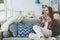 indoor lifestyle portrait of young woman relaxing at home with cup of hot tea or coffee