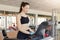 Indoor picture of sporty energetic hard working brunette setting speed of treadmill, getting results, being fond of sport
