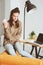 Indoor portrait of beautiful feminine thoughtful young women alone in the room with cup of tea or coffee