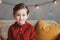 indoor portrait of happy handsome stylish child boy sitting on cozy couch