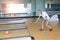 Indoor shot attractive bearded senior caucasian man in white shirt playing bowling in sport club in hotel with happy face. Senior