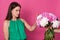 Indoor shot of attractive lady dressed green sundress, refuses beautiful bouquet of white and pink peony flowers from faceless