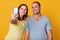 Indoor shot of beautiful young couple looking at camera of cell phone, make selfie portrait, wearing gray and yellow t shirts,