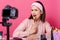 Indoor shot of charismatic artistic young blogger posing in front of camera around cosmetics, holding makeup tool in one hand,