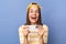 Indoor shot of extremely happy positive optimistic teenager girl wearing baseball cap and stripe T-shirt, holding smart phone,