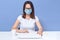 Indoor shot of freelancer accountant working at hone, lady wearing casual white t shirt, eyeglasses and medical mask, sitting at