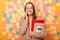 Indoor shot of friendly smiling attractive woman in jacket, holding organizer and paper folder, talking on cell phone with happy