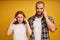 Indoor shot of frustrated thoughtful adult woman and man keep fingers on temples, try to concentrate on difficut question, stand