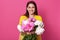 Indoor shot of nice young woman holding beautiful fresh blossoming bouquet of white and pink peony flowers, lady wearing yellow