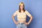 Indoor shot of offended angry teenager girl wearing striped T-shirt and baseball cap posing isolated over blue background, keeps