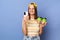 Indoor shot of optimistic charming teenager girl wearing striped T-shirt and baseball cap posing isolated over blue background,