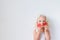 Indoor shot of pretty blonde female with blue eyes, holds two paper red hearts, poses against white background with copy