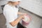 Indoor shot of professional female confectioner in white uniform and chef& x27;s hat, mixing the flour in pink bowl, using a