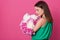 Indoor studio shot of sweet adorable young woman standing isolated over pink background with closed eyes, having peaceful look,