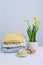 Indoor table setting. Narcissus flower in a pot with knitted sweaters.