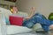 Indoors portrait of young happy relaxed attractive man lying at home sofa couch with headset and laptop listening to internet musi