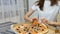 Indoors video of girl`s hand holding a piece of pizza with mushrooms, cheese, maize, olives, red onion rings and