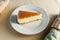 Indulge in the irresistible allure of a rich slice of cheesecake resting on a pristine white plate.
