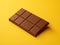 Indulge in Richness: Chunky Chocolate Bar on a Yellow Backdrop