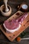 Indulge in the rustic charm of a raw piece of pork loin on a wooden board