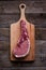 Indulge in the rustic charm of a raw piece of pork loin on a wooden board