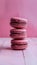 Indulgent trio of chocolate macaroons set against soft pink backdrop