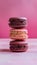 Indulgent trio of chocolate macaroons set against soft pink backdrop