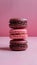 Indulgent trio of chocolate macaroons set against soft pink backdrop