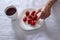 Indulging in Seasonal Delights: Girl\\\'s Hand Reaching for Fresh Strawberries