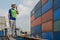 Industrail background of caucasian containers yard and cargo inspector with radio on hand working at containers loading area