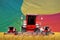 industrial 3D illustration of 4 bright red combine harvesters on rural field with flag background, Benin agriculture concept