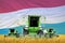 Industrial 3D illustration of four light green combine harvesters on rural field with flag background, Luxembourg agriculture