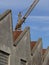 Industrial archeology buildings in the city of Busto Arsizio. Facade of ancient factory shed. Construction crane