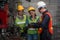 Industrial background of asian male mechanic engineer supervisor explaining machine work procedure to new female mechanic engineer