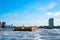 Industrial barge passing business center in London on the River Thames.