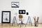 Industrial basket with kraft paper rolls and a framed poster in a white, minimalist home office interior of a freelancer architect