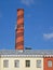 Industrial brown pipe over yellow building, sky,