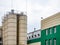 Industrial building external view with tanks, blue sky. Green a