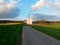 Industrial building in the middle of fields and meadows beside which is an asphalt road and bridge