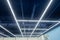Industrial ceiling painted neutral blue. Lamps are placed in the form of longitudinal and transverse lines. Creative ceiling solut